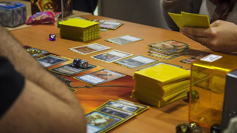 Players with cards and dice during a Magic: The Gathering Commander game