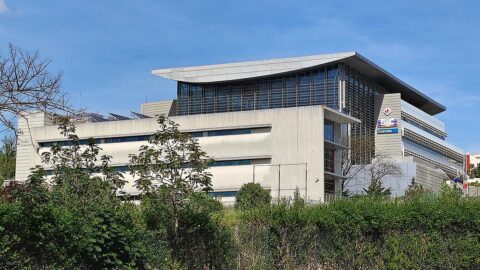 Modern television broadcaster headquarters building under a blue sky