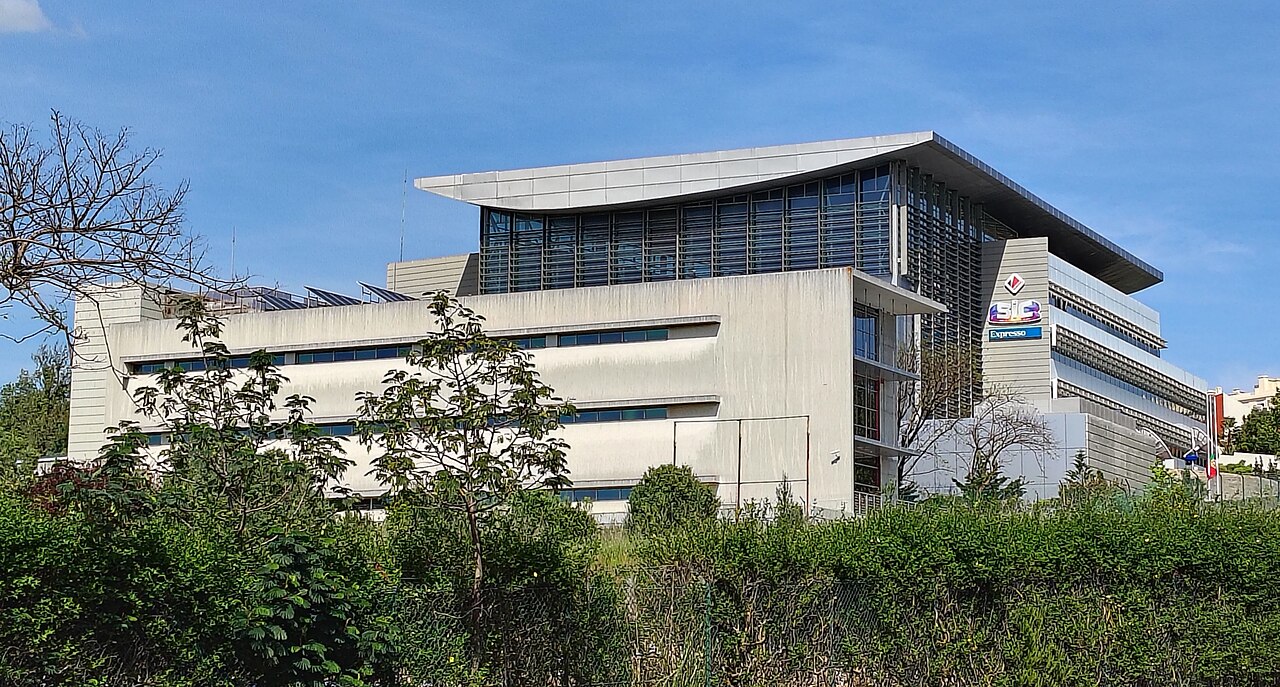 Modern television broadcaster headquarters building under a blue sky
